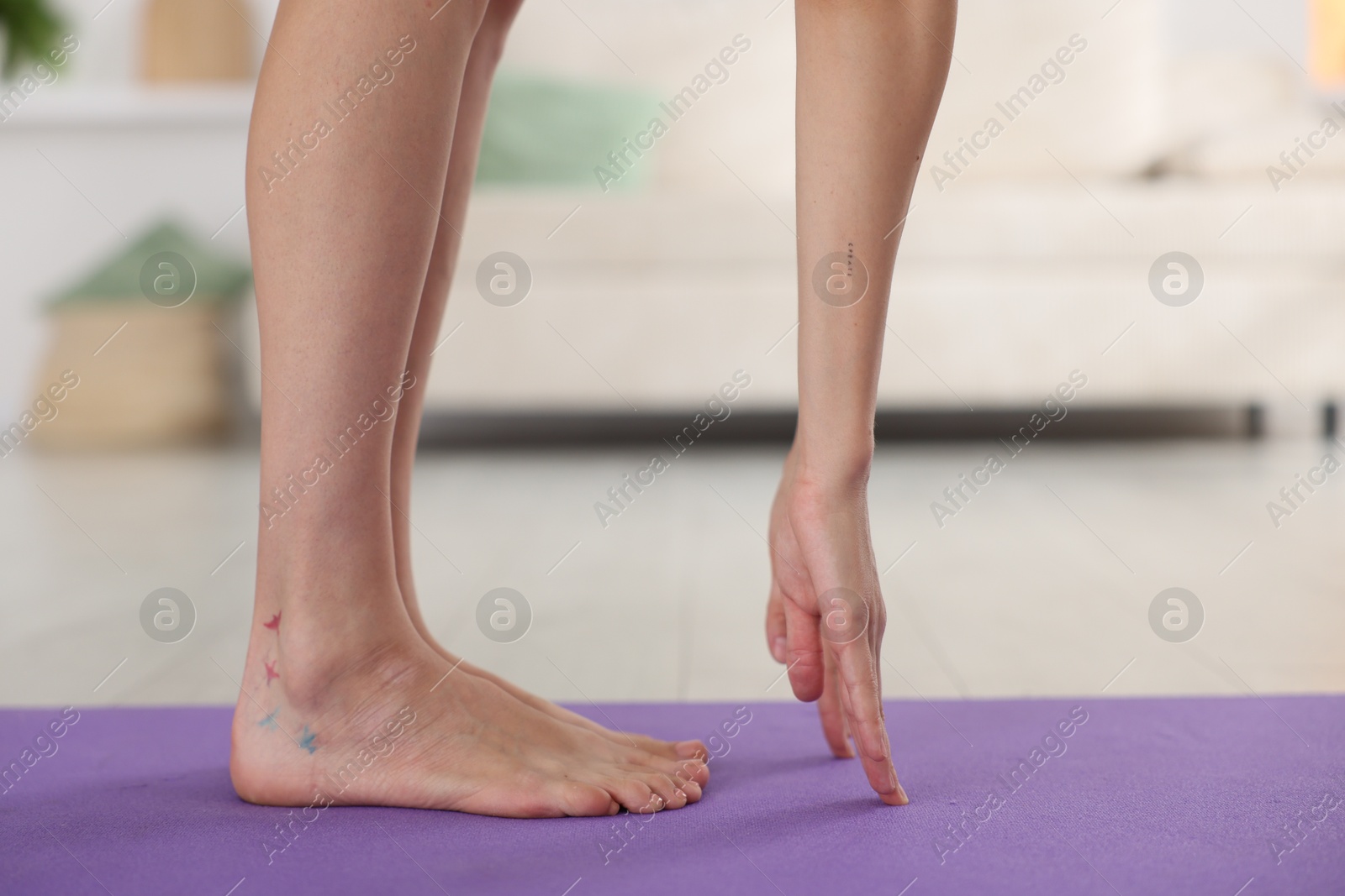 Woman stretching on mat at home, closeup Photo of Woman stretching on mat at home, closeup