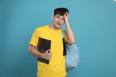 Photo of Worried student with laptop on light blue background