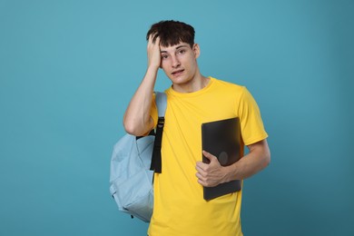 Photo of Worried student with laptop on light blue background