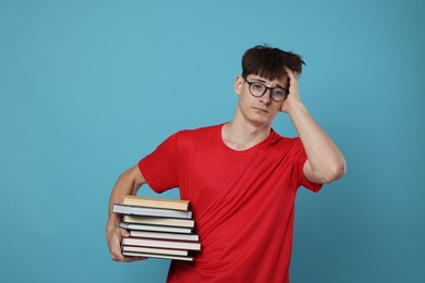 Photo of Exam result. Worried student with books on light blue background