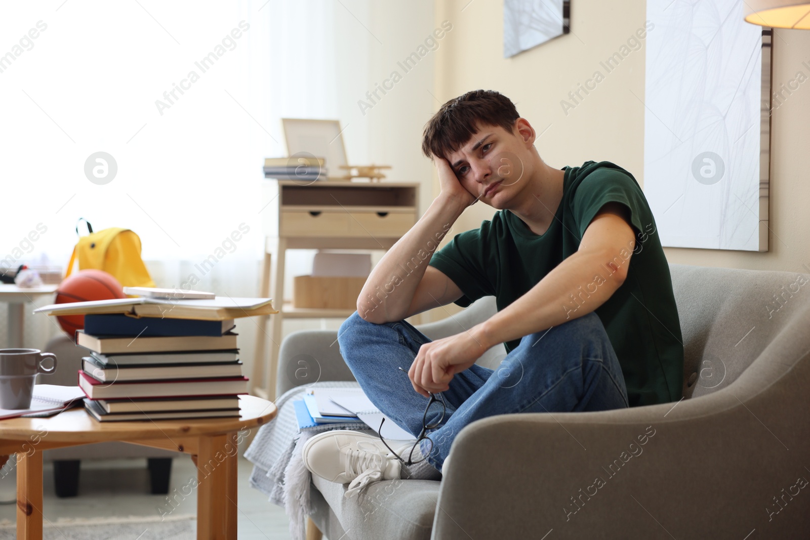 Tired student preparing for exam at table indoors Photo of Tired student preparing for exam at table indoors