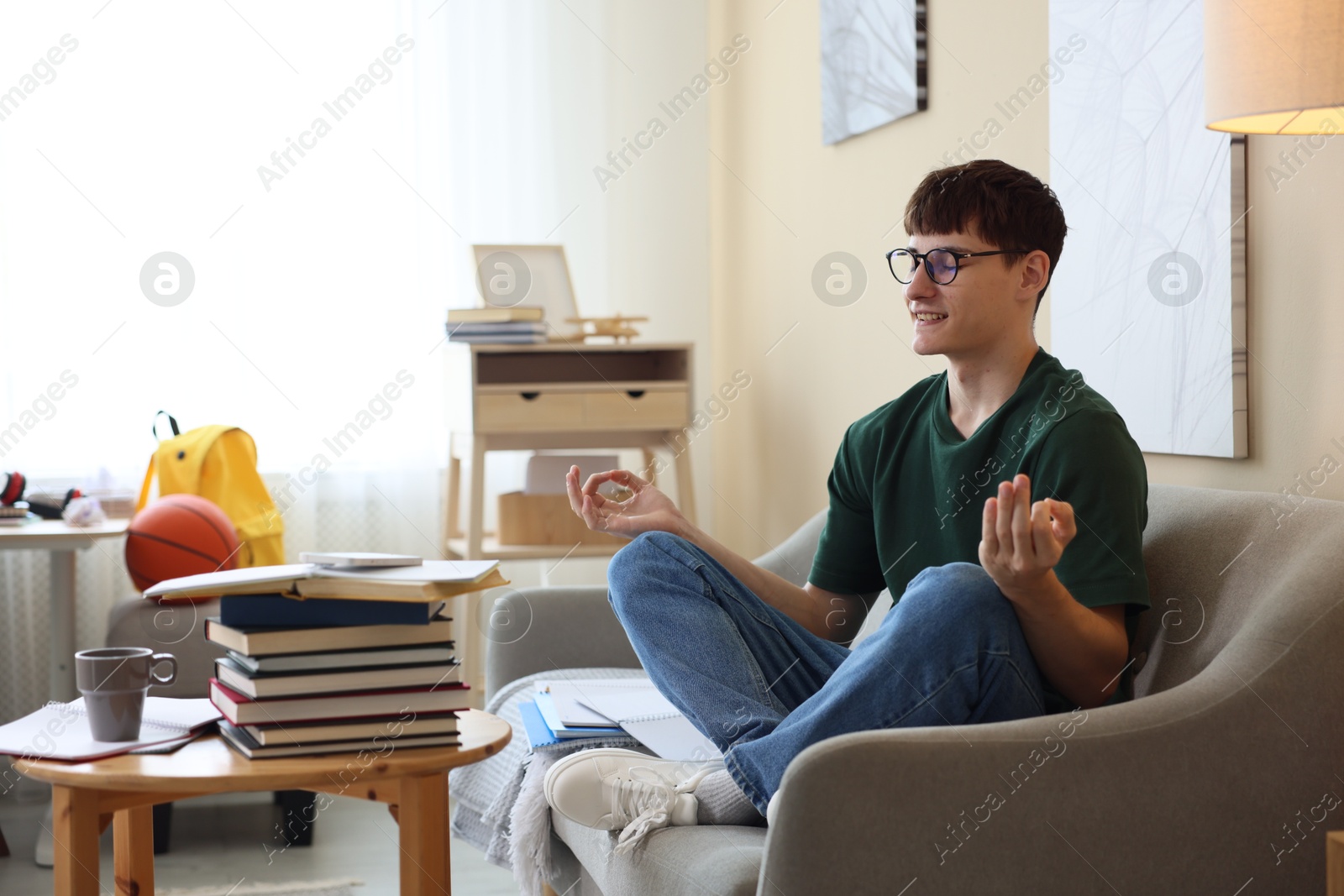 Student preparing for exam and meditating at home Photo of Student preparing for exam and meditating at home