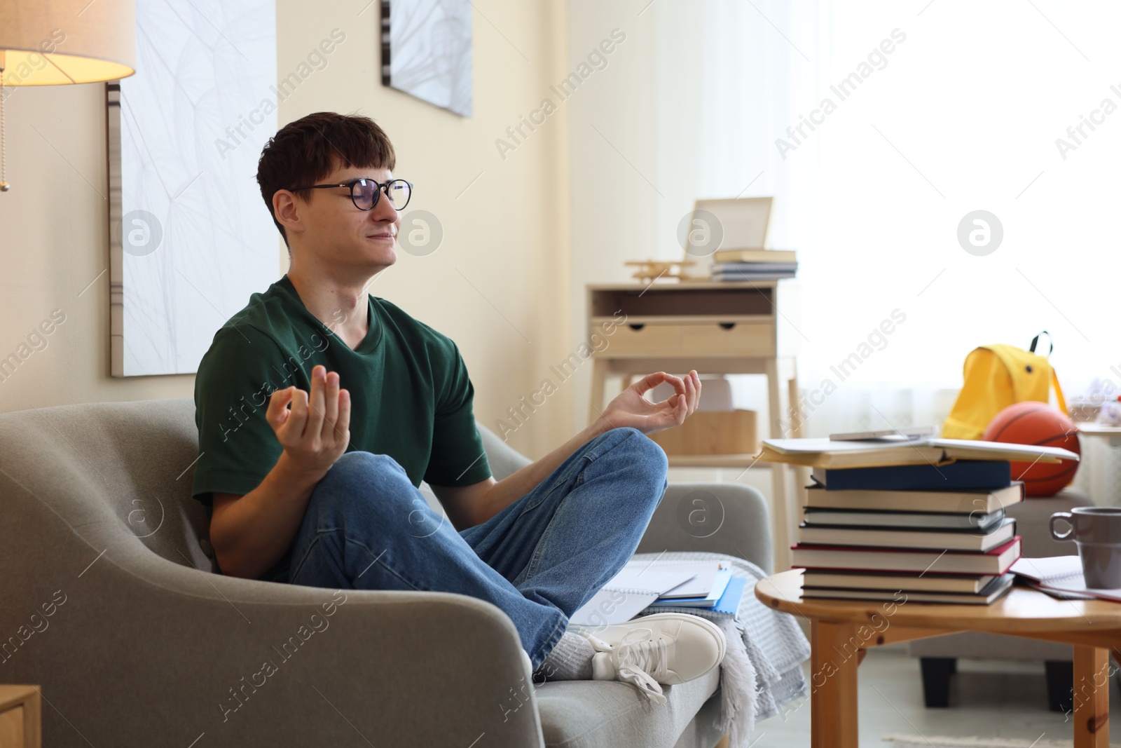 Student preparing for exam and meditating at home Photo of Student preparing for exam and meditating at home