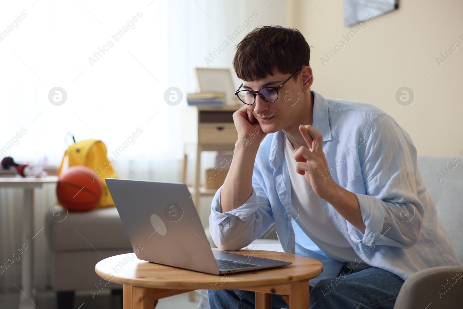 Worried student crossing fingers for good exam result at table indoors Photo of Worried student crossing fingers for good exam result at table indoors
