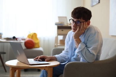 Photo of Tired student preparing for exam at table indoors