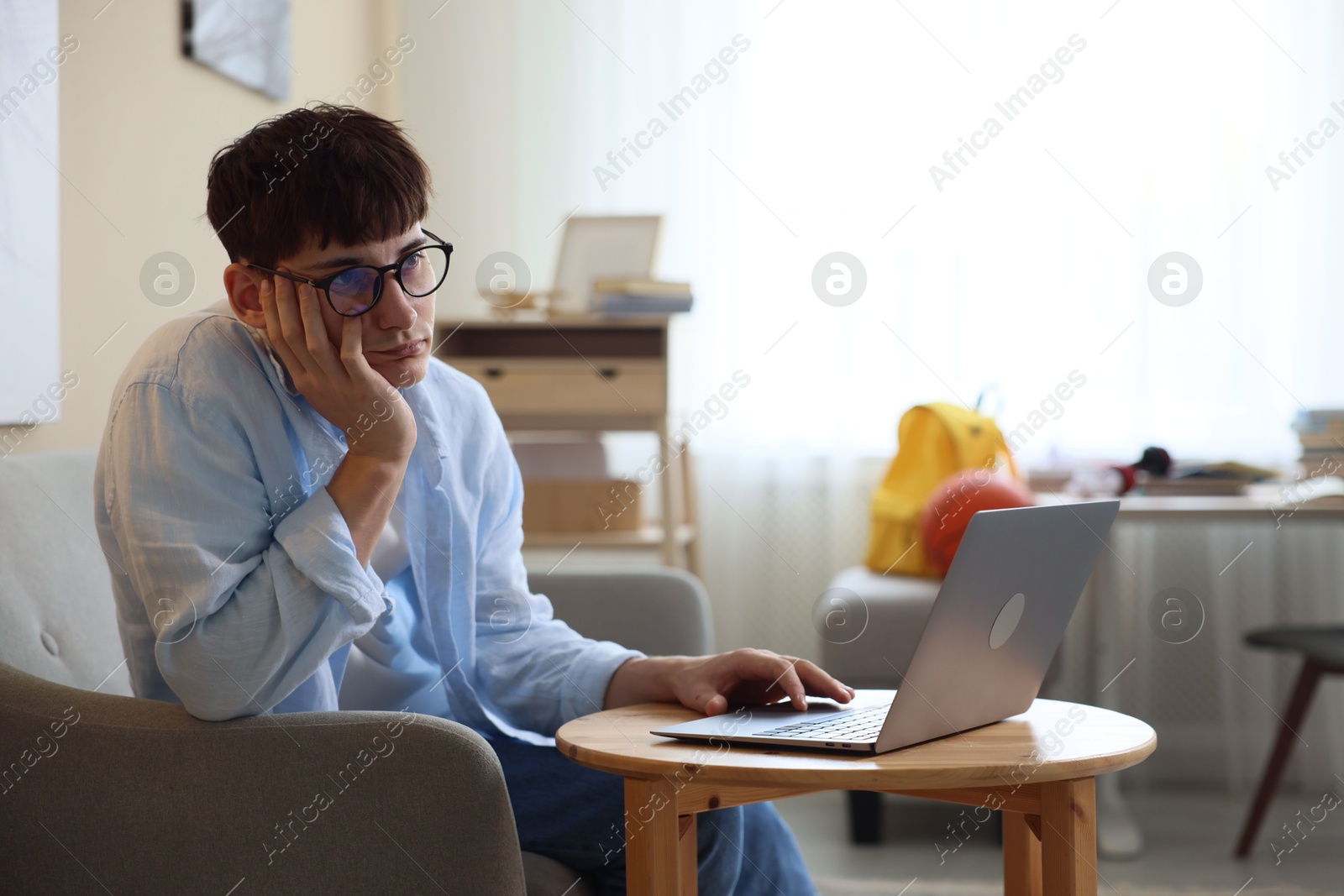 Tired student preparing for exam at table indoors Photo of Tired student preparing for exam at table indoors