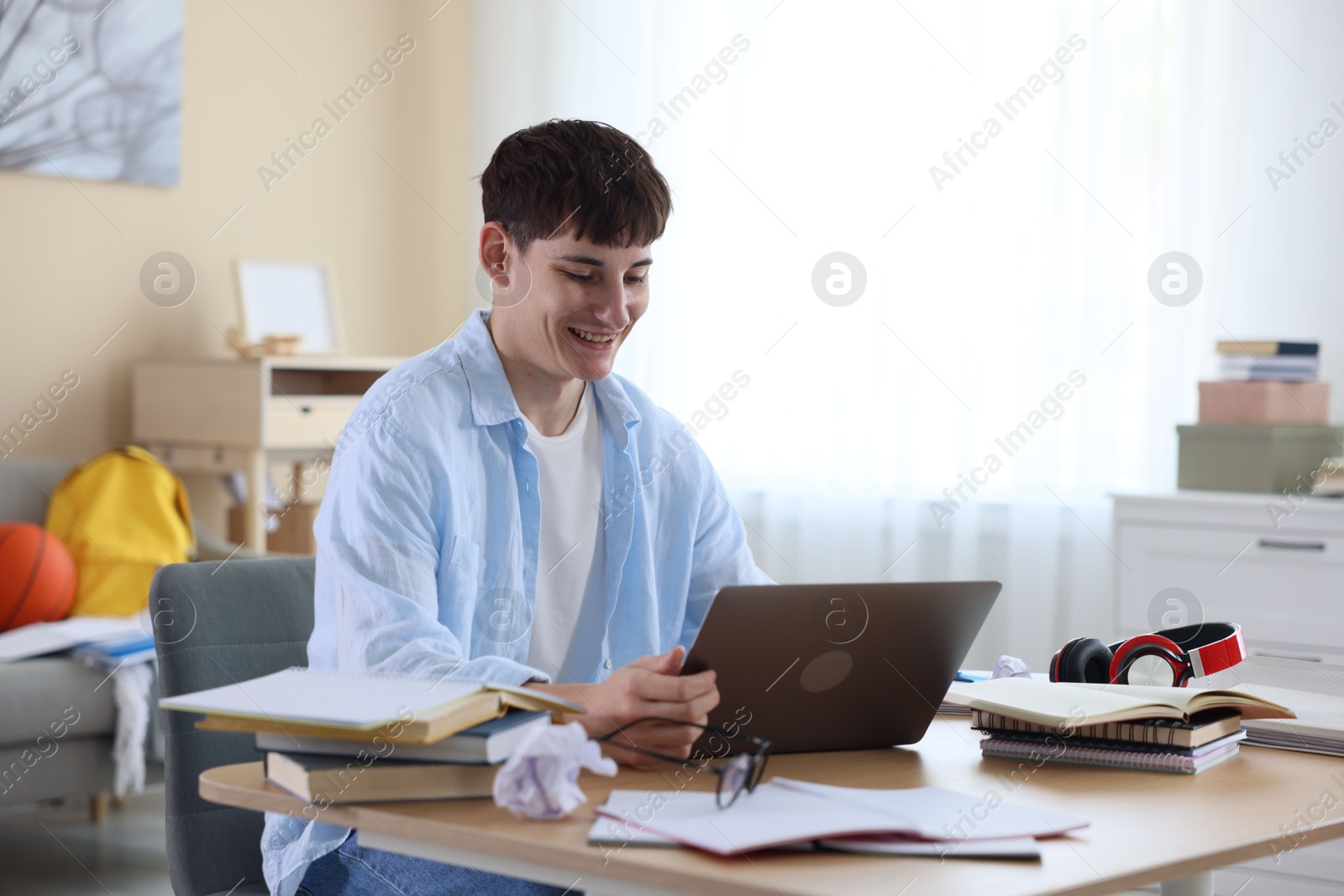 Happy student celebrating good exam result at table indoors Photo of Happy student celebrating good exam result at table indoors