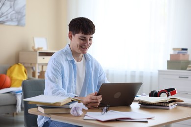 Photo of Happy student celebrating good exam result at table indoors