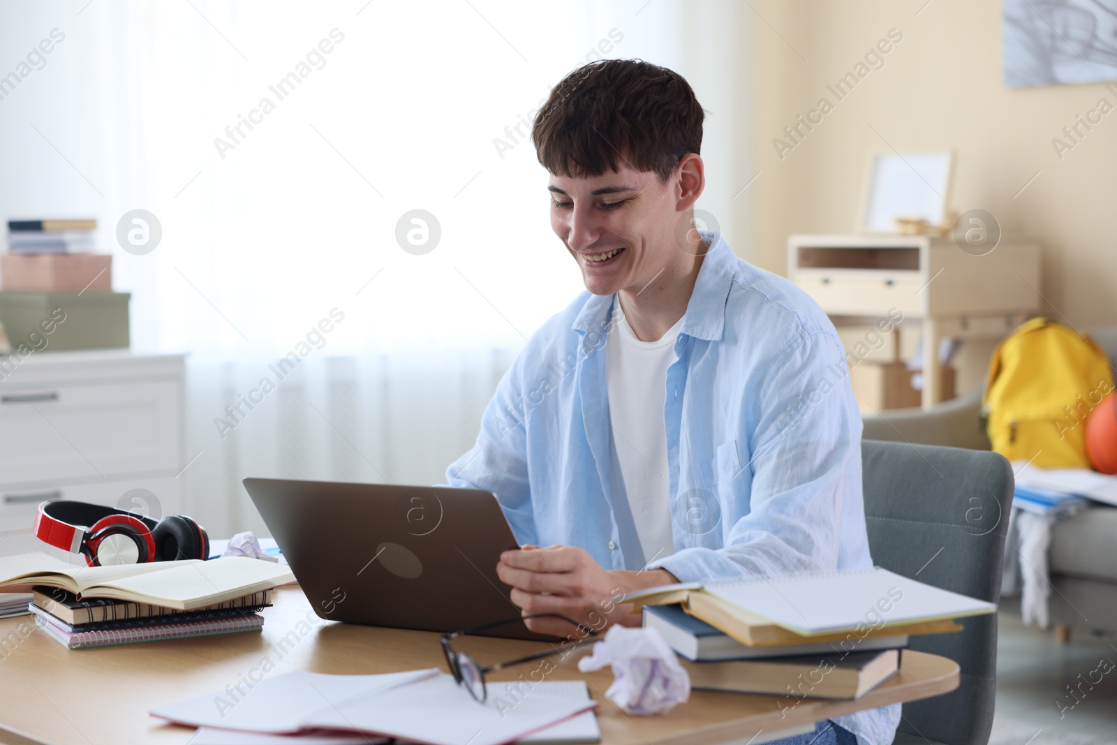 Happy student celebrating good exam result at table indoors Photo of Happy student celebrating good exam result at table indoors