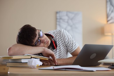 Photo of Worried student preparing for exam at table indoors