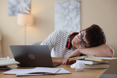 Photo of Worried student preparing for exam at table indoors