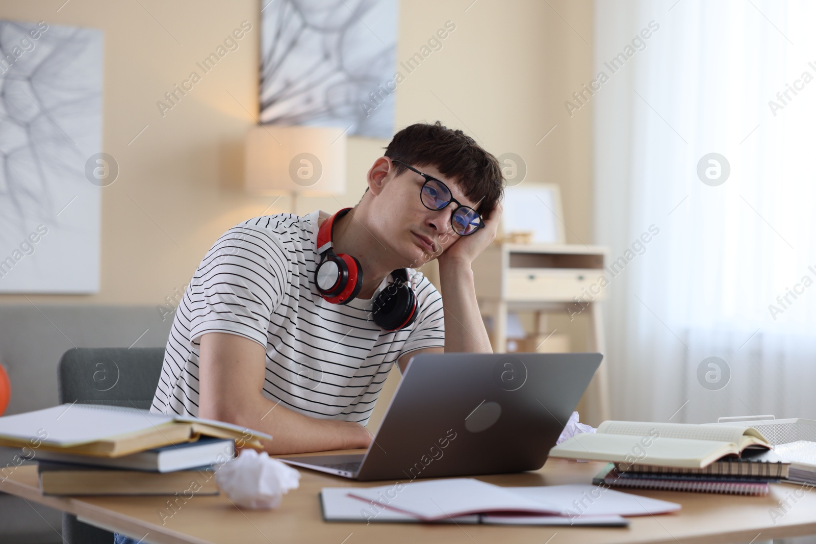 Worried student preparing for exam at table indoors Photo of Worried student preparing for exam at table indoors