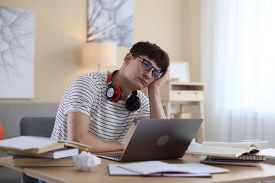 Photo of Worried student preparing for exam at table indoors
