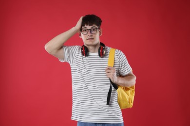 Photo of Student worried about his exam result on red background