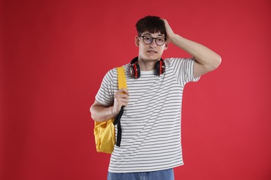 Photo of Student worried about his exam result on red background
