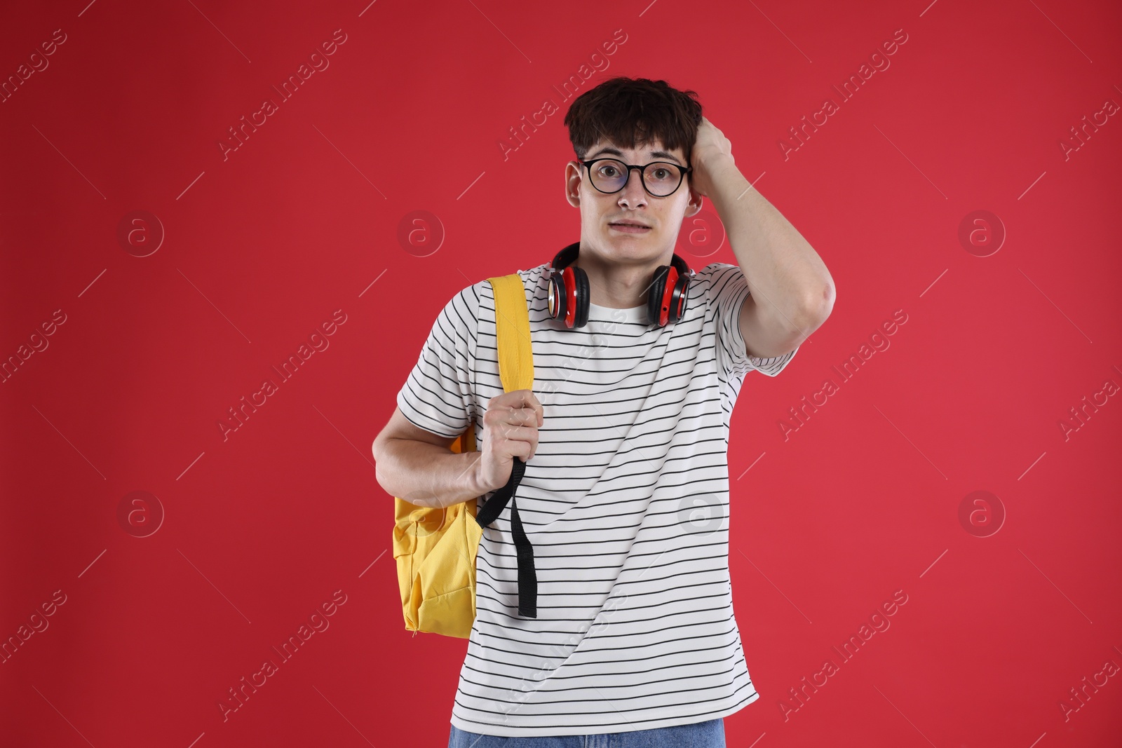 Student worried about his exam result on red background Photo of Student worried about his exam result on red background
