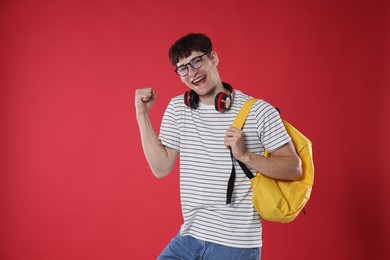 Photo of Happy student celebrating good exam result on red background
