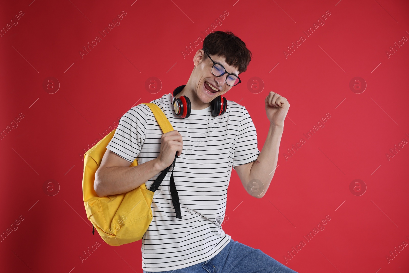 Happy student celebrating good exam result on red background Photo of Happy student celebrating good exam result on red background