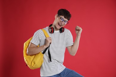 Photo of Happy student celebrating good exam result on red background