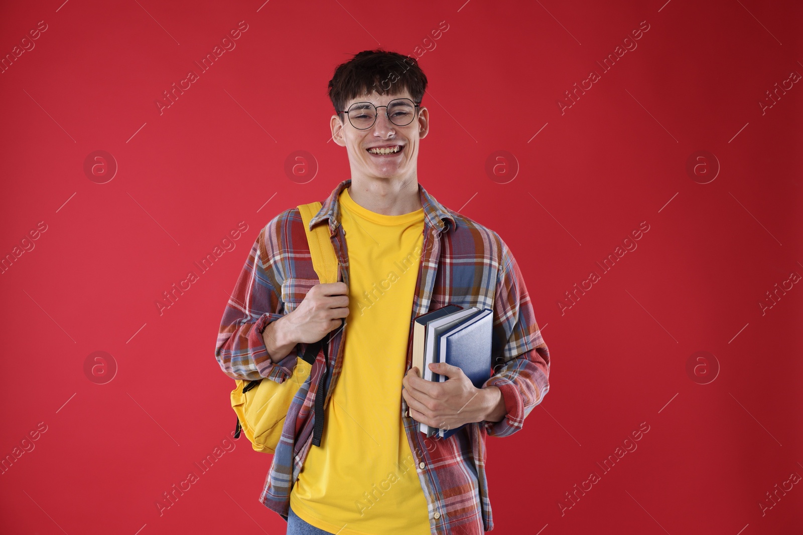 Good exam result. Happy student with books on red background Photo of Good exam result. Happy student with books on red background