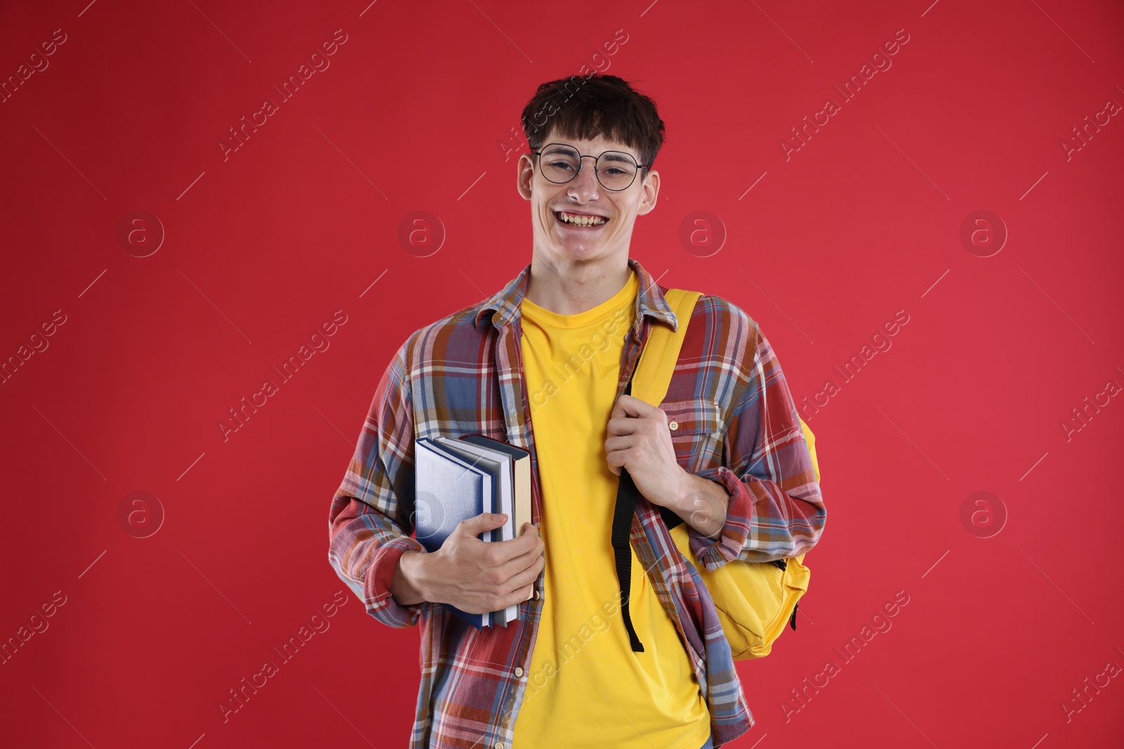 Good exam result. Happy student with books on red background Photo of Good exam result. Happy student with books on red background