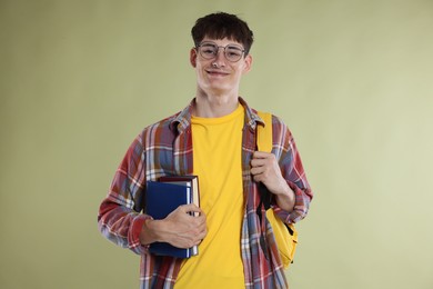 Photo of Good exam result. Happy student with books on light olive background