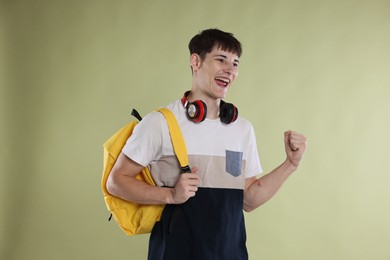 Photo of Happy student celebrating good exam result on light olive background