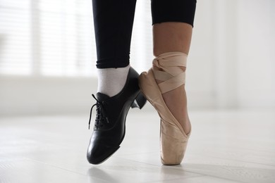 Photo of Teenage girl in tap and pointe shoe indoors, closeup