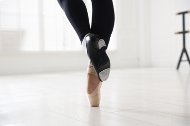 Photo of Teenage girl in tap and pointe shoe indoors, closeup