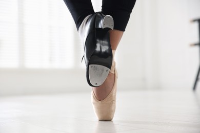 Photo of Teenage girl in tap and pointe shoe indoors, closeup