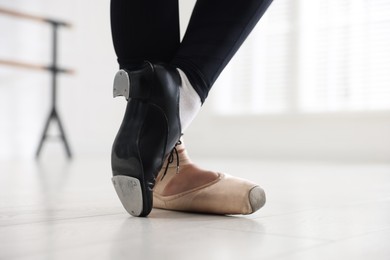 Photo of Teenage girl in tap and pointe shoe indoors, closeup