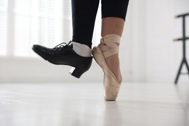 Photo of Teenage girl in tap and pointe shoe indoors, closeup