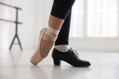 Photo of Teenage girl in tap and pointe shoe indoors, closeup