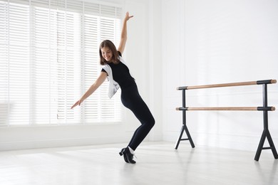 Photo of Teenage girl in tap shoes dancing indoors