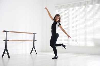 Photo of Teenage girl in tap shoes dancing indoors