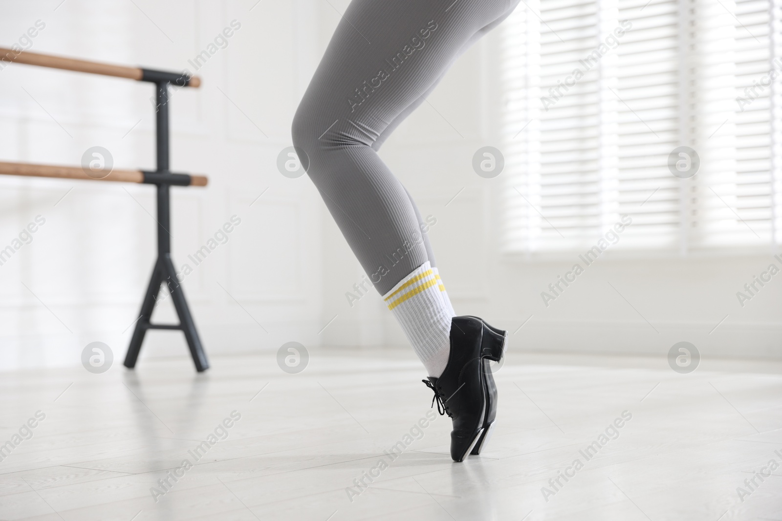 Photo of Teenage girl in tap shoes training indoors, closeup