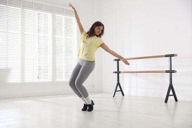 Photo of Teenage girl in tap shoes dancing indoors