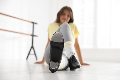 Photo of Teenage girl in tap shoes indoors, selective focus
