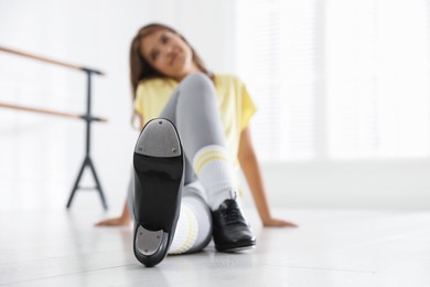 Photo of Teenage girl in tap shoes indoors, selective focus