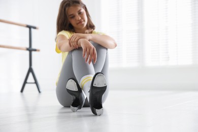 Photo of Teenage girl in tap shoes indoors, selective focus