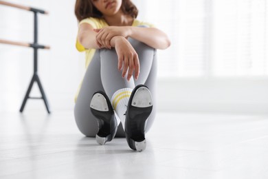 Photo of Teenage girl in tap shoes indoors, closeup
