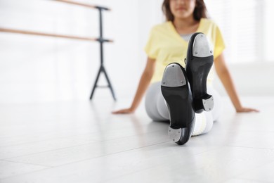 Photo of Teenage girl in tap shoes indoors, closeup