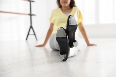 Photo of Teenage girl in tap shoes indoors, closeup