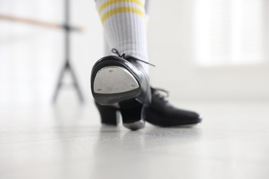 Photo of Teenage girl in tap shoes indoors, closeup