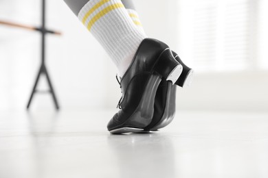 Photo of Teenage girl in tap shoes indoors, closeup