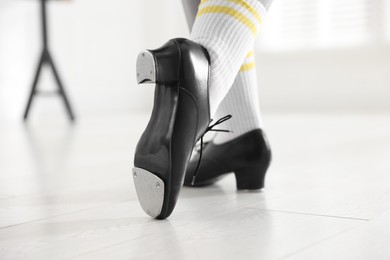 Photo of Teenage girl in tap shoes indoors, closeup