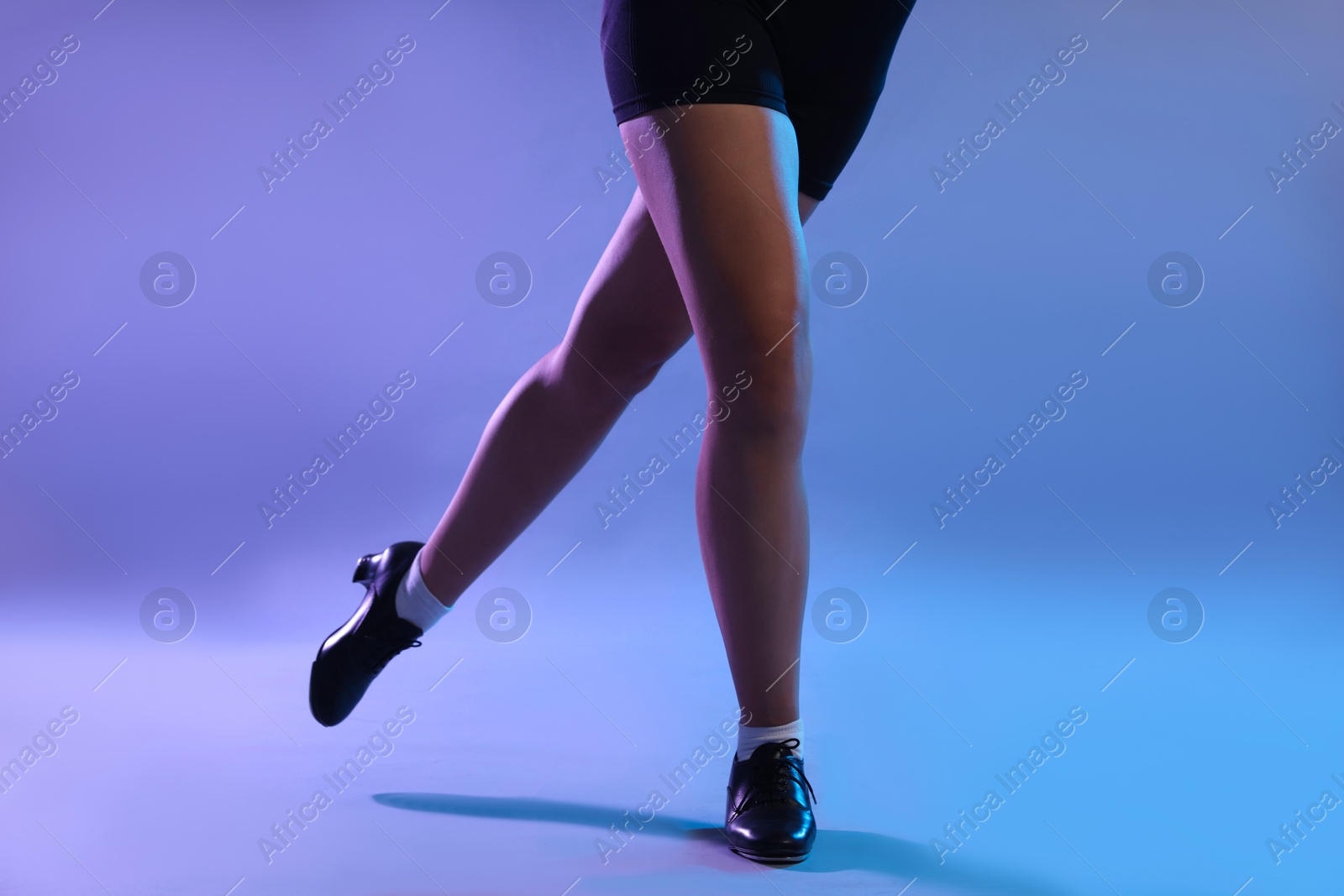 Teenage girl in tap shoes dancing on color background, closeup Photo of Teenage girl in tap shoes dancing on color background, closeup