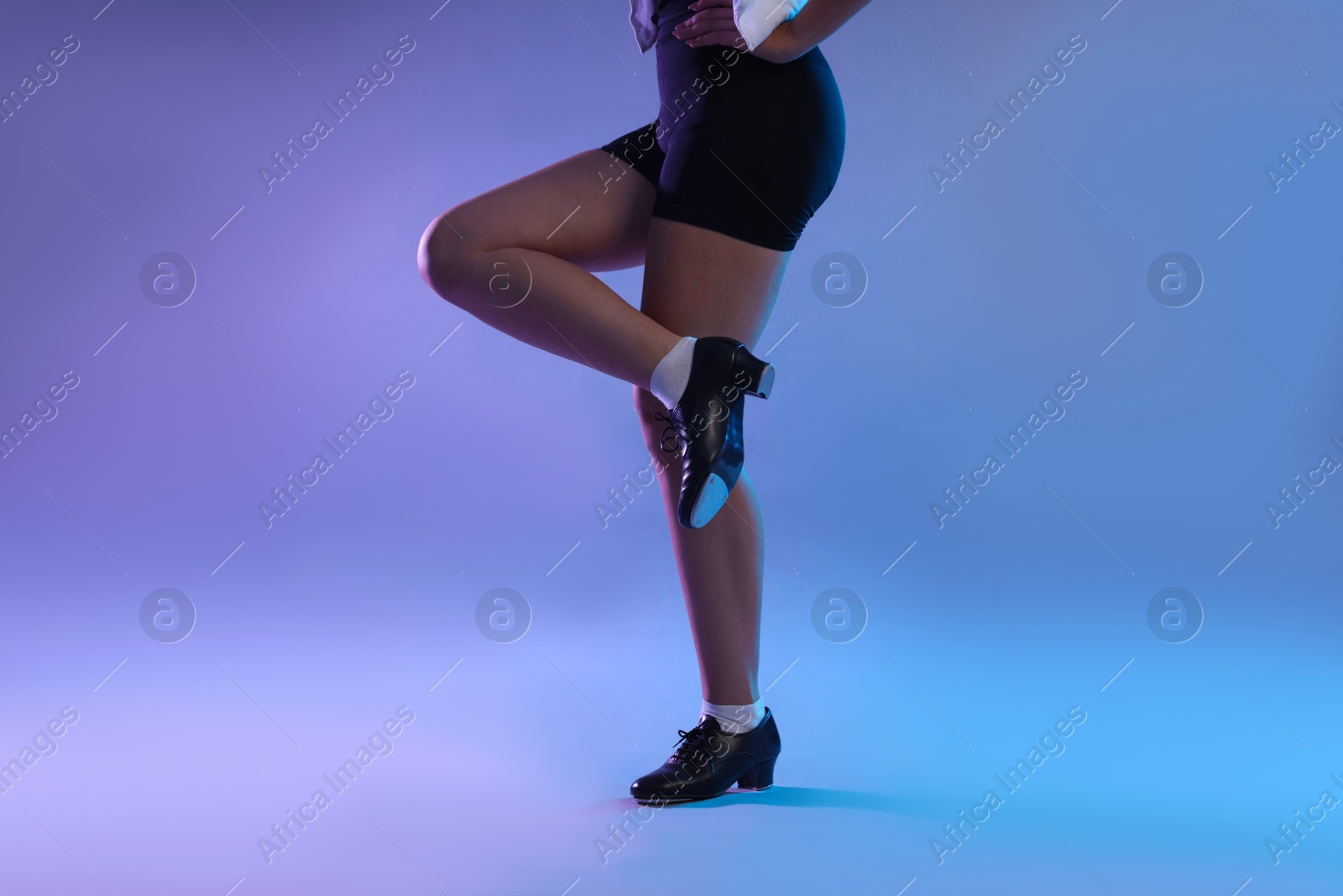 Photo of Teenage girl in tap shoes on color background, closeup
