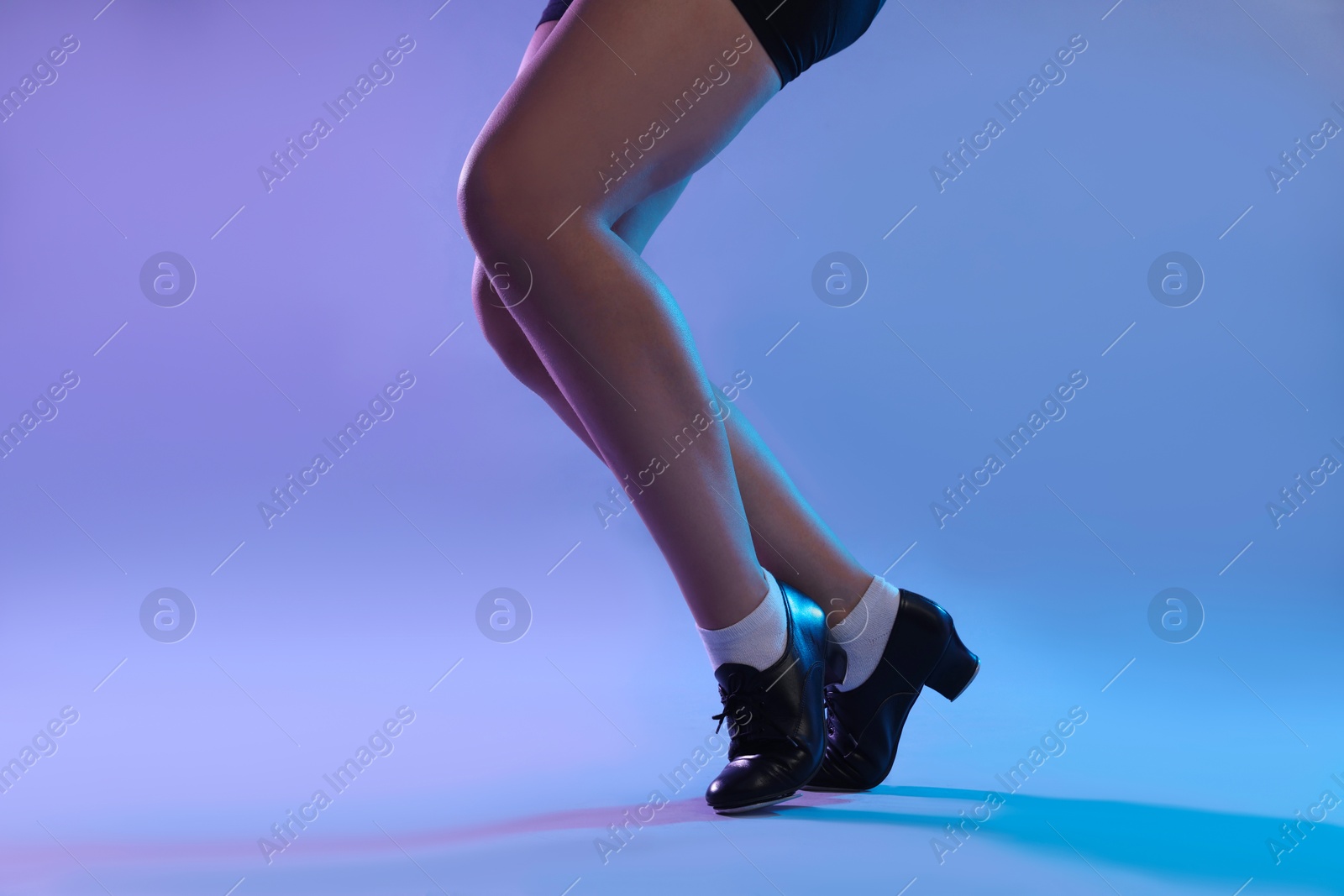 Teenage girl in tap shoes dancing on color background, closeup Photo of Teenage girl in tap shoes dancing on color background, closeup