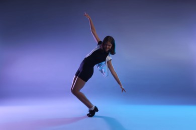 Photo of Teenage girl in tap shoes dancing on color background